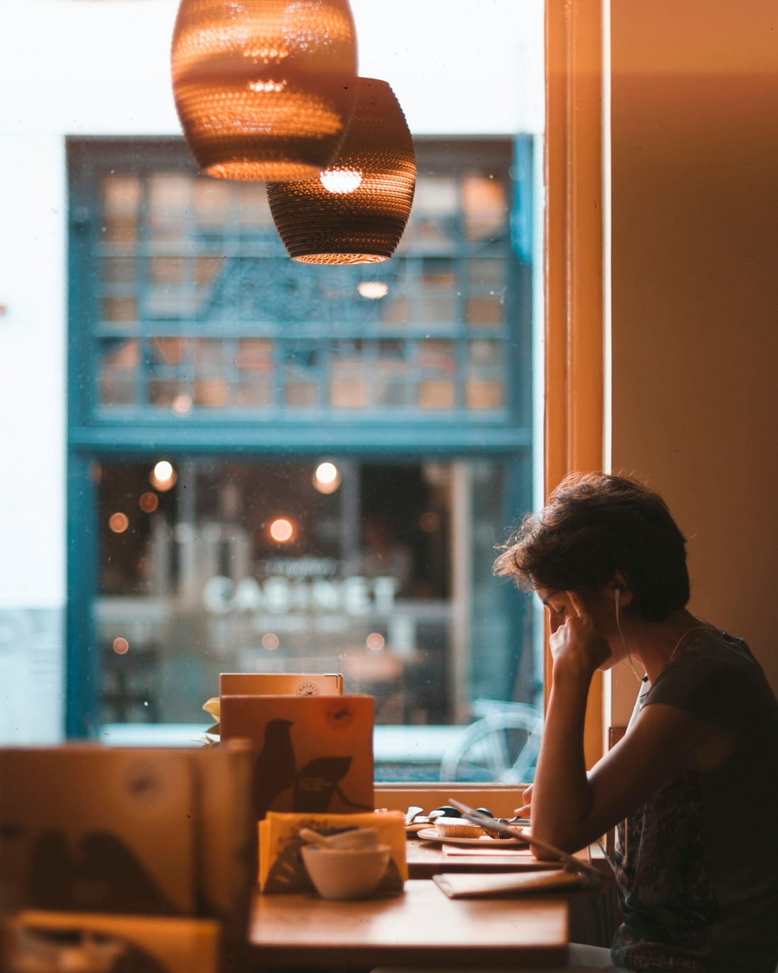 man holding on tablet while sitting on chair in restaurant