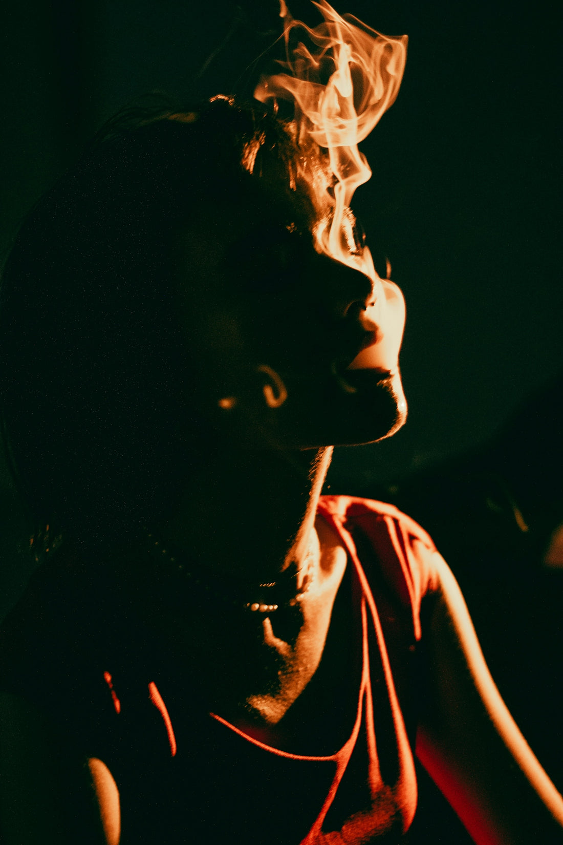 a man is smoking a cigarette in the dark