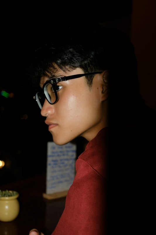 A man wearing glasses looking at his cell phone