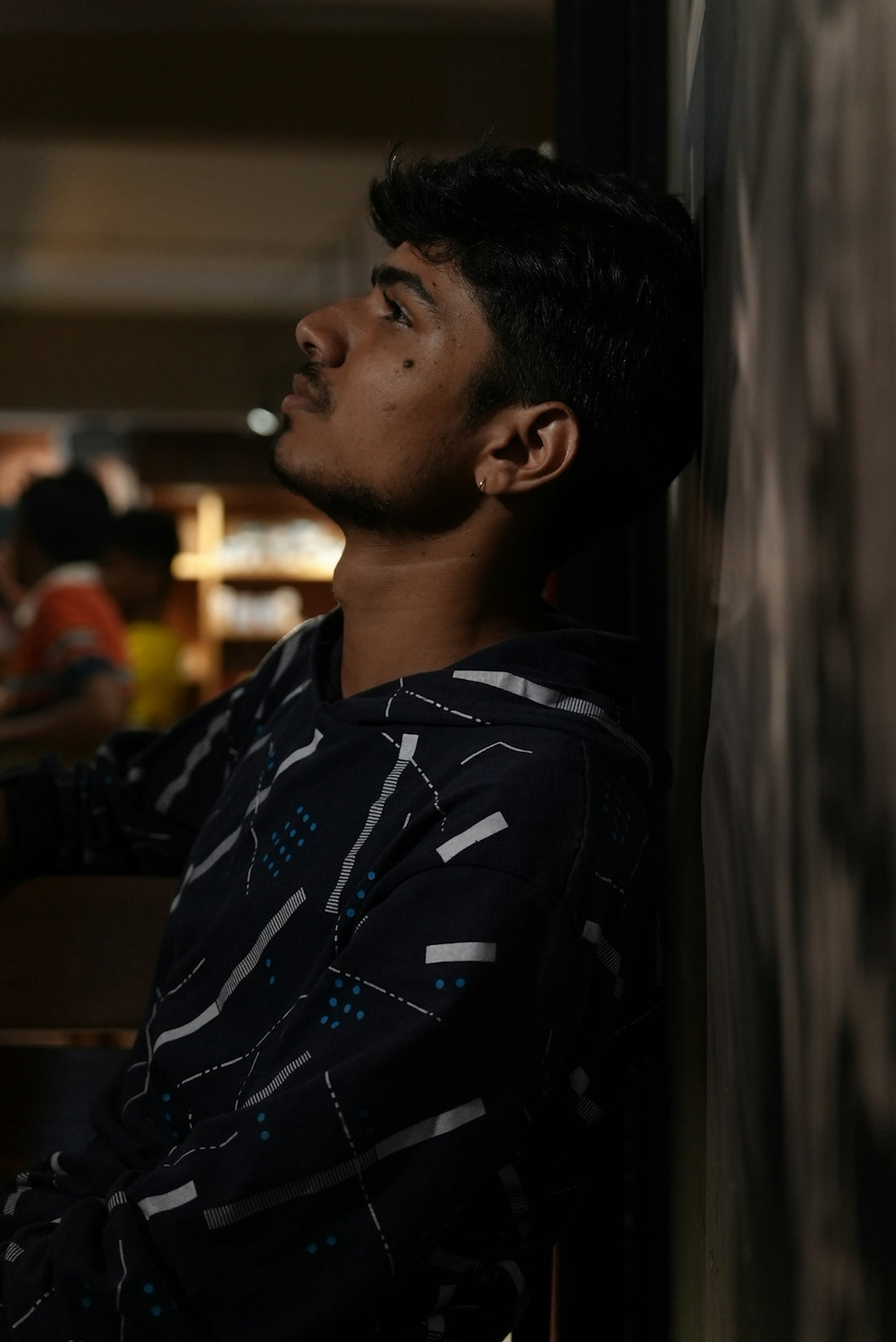 A man leaning against a wall in a restaurant